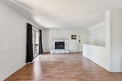 A living room with a fireplace and hardwood floors.