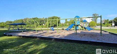 A playground with a blue slide and a green swing set.
