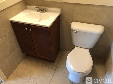 A white toilet sits next to a sink in a bathroom.