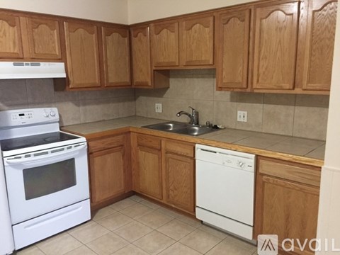 A kitchen with wooden cabinets and white appliances.