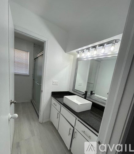 A bathroom with a sink, mirror, and cabinets.