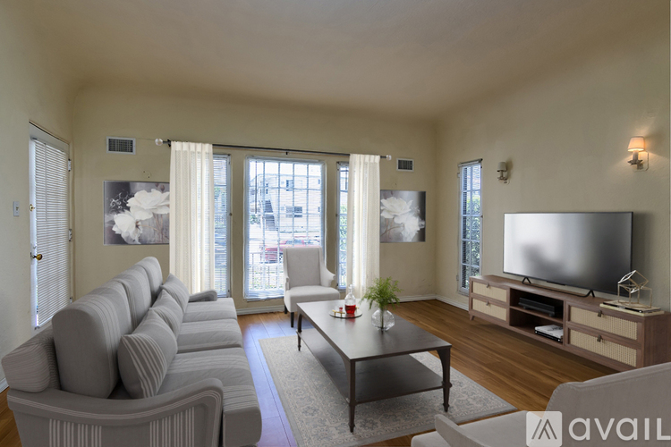 A living room with a grey couch, a coffee table, and a television.