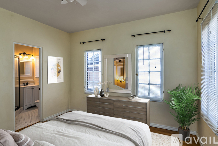 A bedroom with a bed, dresser, and window.