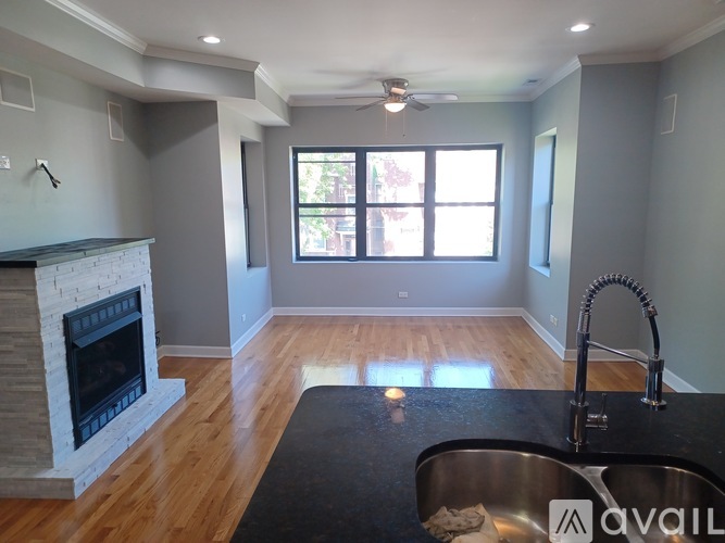 A modern kitchen with a fireplace and a large window.