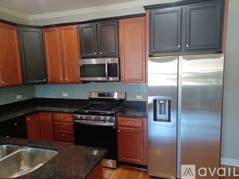 A kitchen with wooden cabinets and a stainless steel refrigerator.