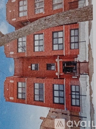 A red brick building with a white trim and a balcony on the second floor.