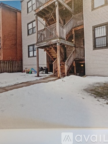 A wooden deck with a staircase leading to a balcony.