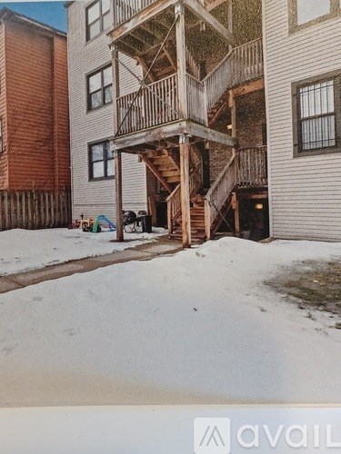 A wooden deck with a staircase leading to a balcony.