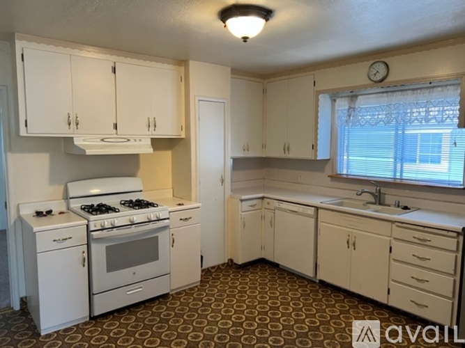 A kitchen with white appliances and cabinets.
