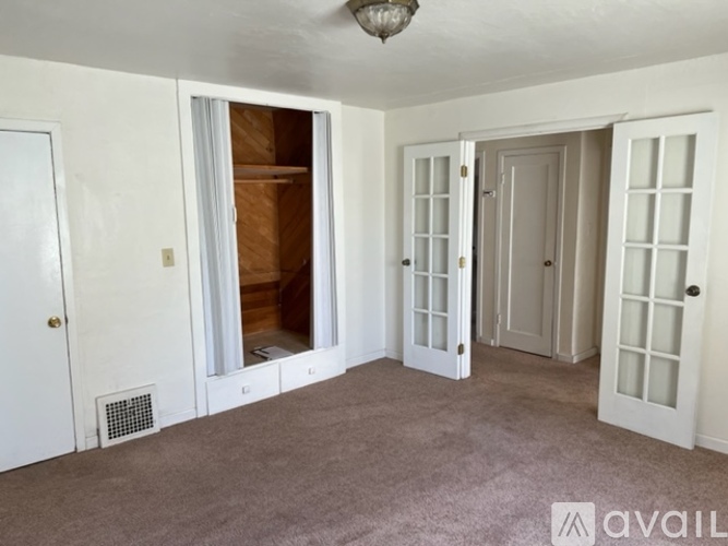 A room with white doors and a carpeted floor.