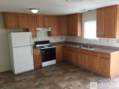 A kitchen with wooden cabinets and a white refrigerator.