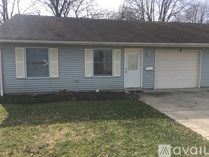 A house with a grey roof and a white garage door.