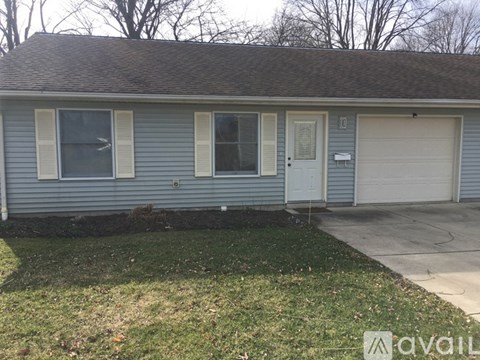 A house with a grey roof and a white garage door.