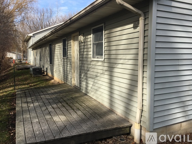 A house with a grey siding and a wooden deck.
