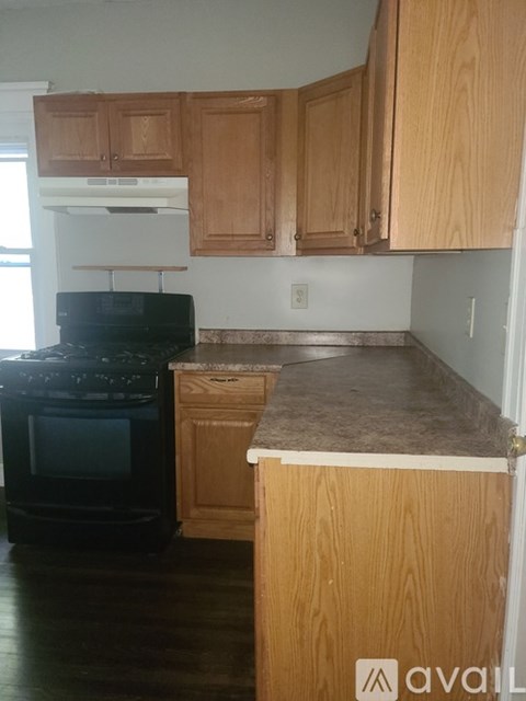 A kitchen with wooden cabinets and a black stove top oven.