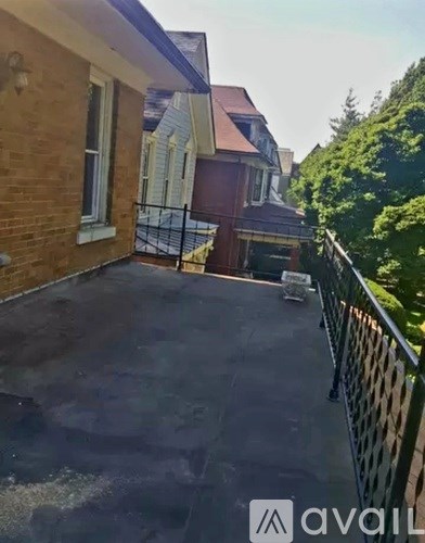 A black car is parked on the driveway of a house.