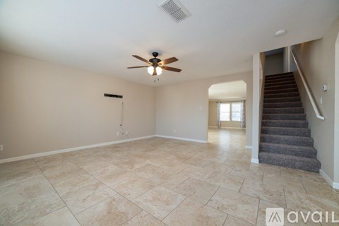 A spacious room with a fan and tiled floor.