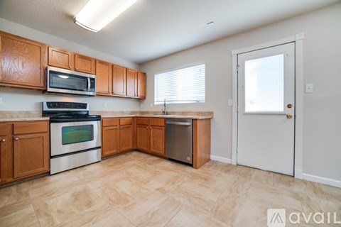 A kitchen with wooden cabinets and a white door.