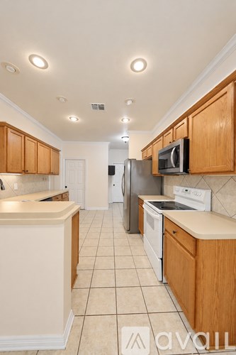 A kitchen with wooden cabinets and white appliances.