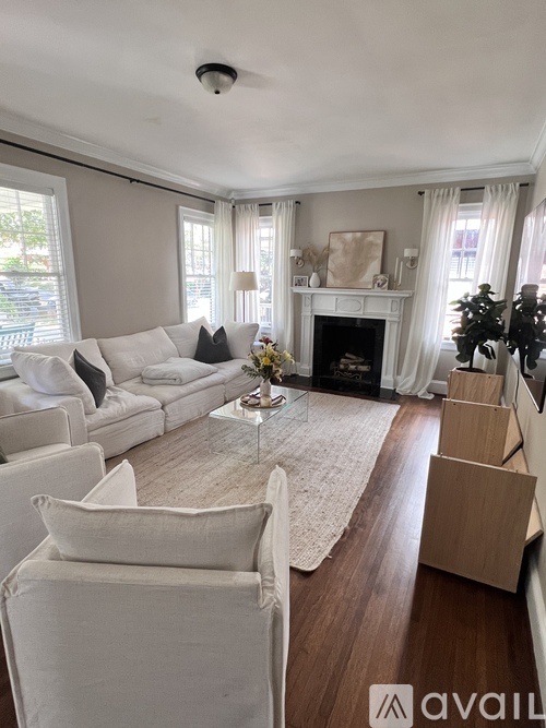 A living room with a white couch and a fireplace.
