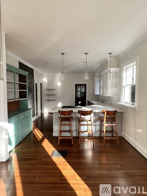 A kitchen with a dining table and chairs in the middle.