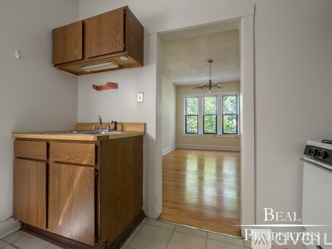 A kitchen with wooden cabinets and a white stove.