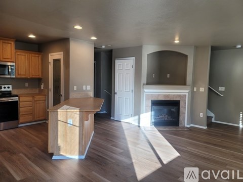 A kitchen with wooden cabinets and a fireplace in the living room.