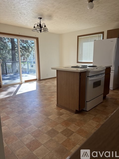 A kitchen with a white fridge and a brown counter.