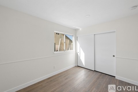 A room with a window and wooden flooring is available for rent.