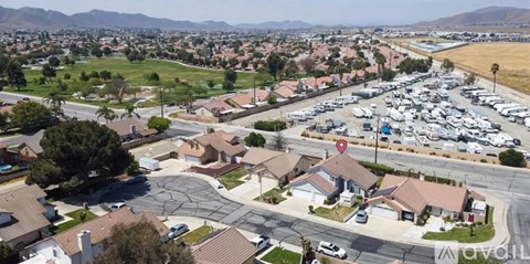 A suburban neighborhood with a parking lot and houses.