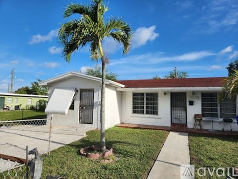 A house with a palm tree in front of it.