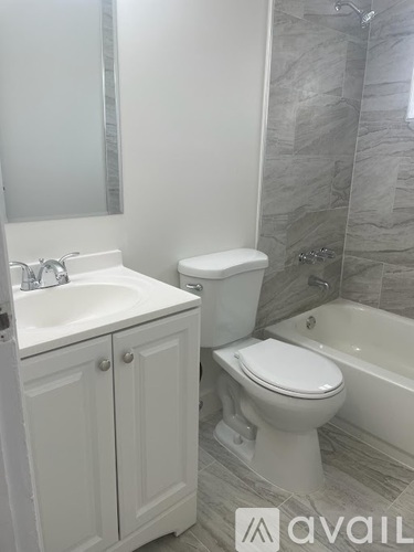 A bathroom with a toilet, sink, and bathtub.