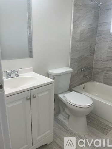 A bathroom with a toilet, sink, and bathtub.