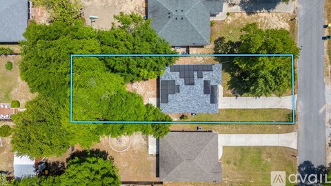 A bird's eye view of a residential area with a highlighted property for sale.