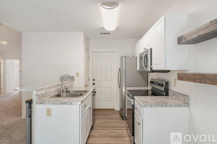 A kitchen with white cabinets and a granite countertop.