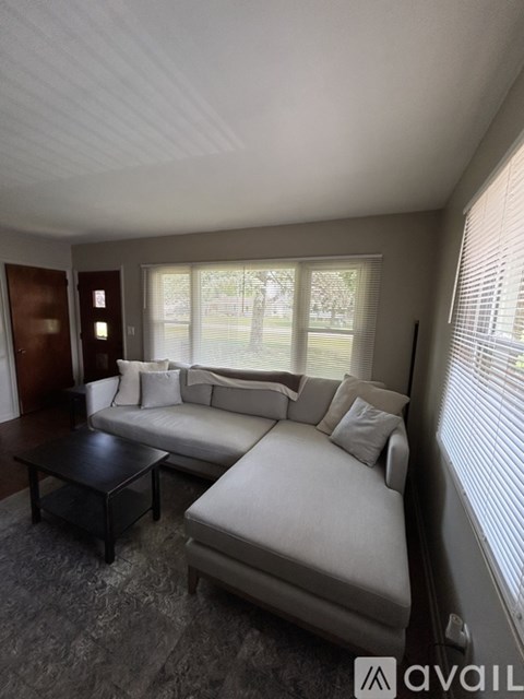 A living room with a white couch and a black coffee table.