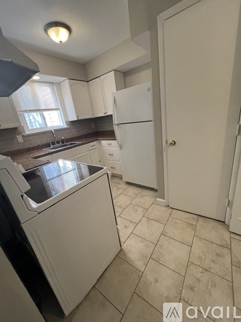 A kitchen with white appliances and a white door.