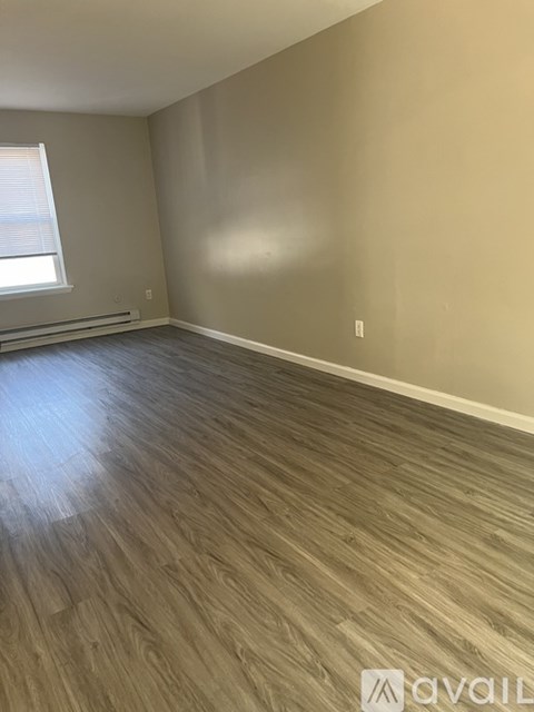 A room with wooden flooring and a window.