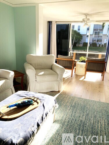 A living room with a white chair and a blue couch.