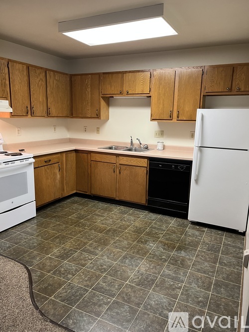 A kitchen with wooden cabinets and a white refrigerator.