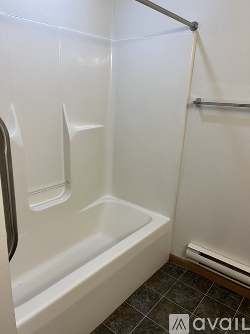 A white bathroom with a tub and a towel rack.
