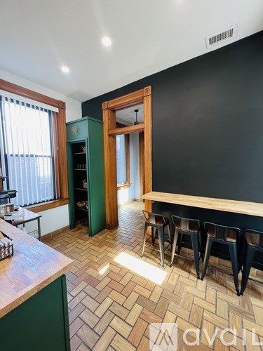 A kitchen with a green cabinet and a wooden floor.