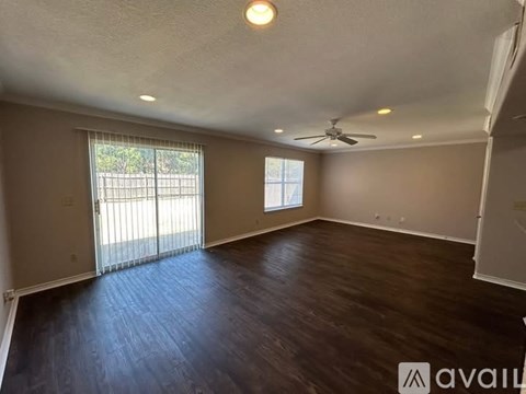 A room with a ceiling fan and sliding glass doors.
