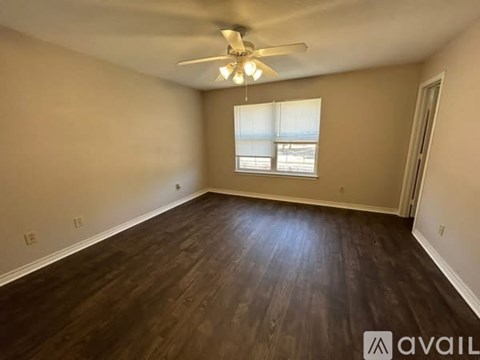 A room with wooden flooring and a ceiling fan.