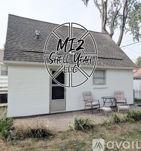 A white building with a sign that reads "M12 Shell Yeah LLC" in front of it.