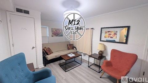 A living room with a blue chair, a red chair, a sofa, and a coffee table.