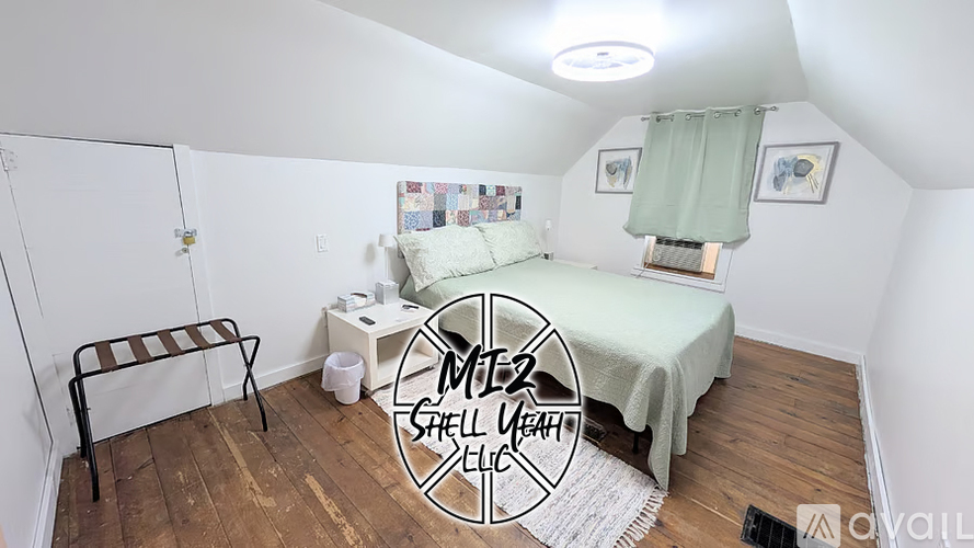 A bedroom with a bed, a chair, and a small table.