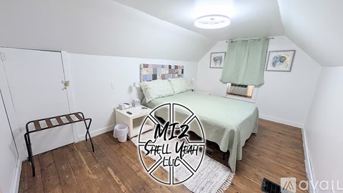 A bedroom with a bed, a chair, and a small table.