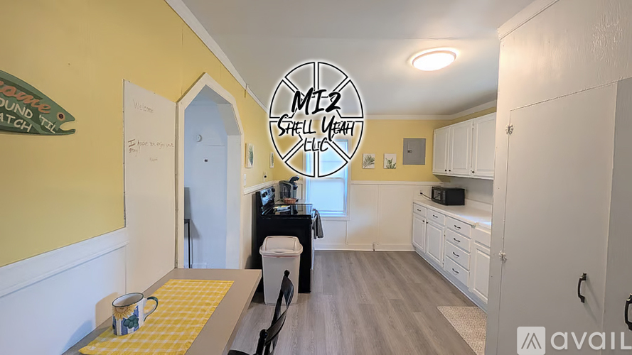 A kitchen with a yellow wall and a dining table with chairs.