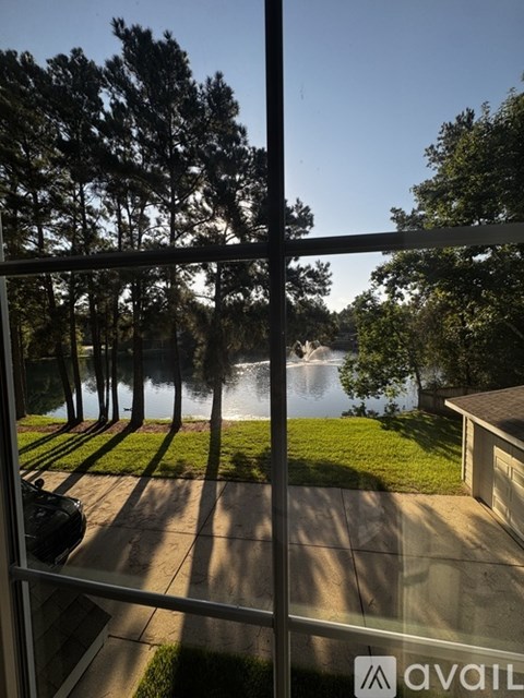 A view from inside a building looking out to a lake and trees.